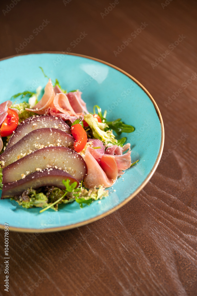 A gourmet salad featuring tomatoes and wine-marinated pear, elegantly presented on a blue plate. Ideal for themes of fine dining, healthy eating, and culinary artistry A gourmet salad featuring tomatoes and wine-marinated pear, elegantly presented on a blue plate. Ideal for themes of fine dining, healthy eating, and culinary artistry