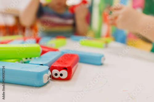 Brightly coloured building blocks on table with children in background photo