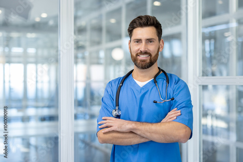 Photos Confident doctor in blue scrubs with stethoscope standing proud in modern hospital setting