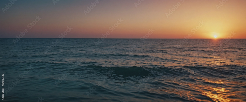Obraz premium A serene sunset over calm ocean waters, highlighting tranquil waves at dusk