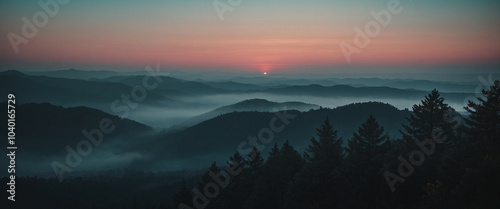 Stunning sunrise view over misty mountains with a soft gradient sky in early morning light