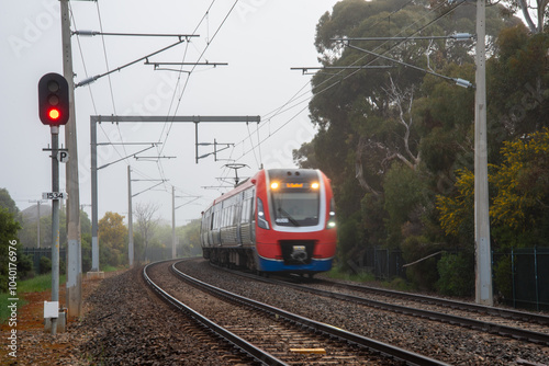 A suburban train on the tracks at Brighton, Adelaide on a foggy day