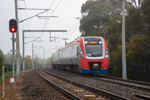 A suburban train on the tracks at Brighton, Adelaide on a foggy day photo