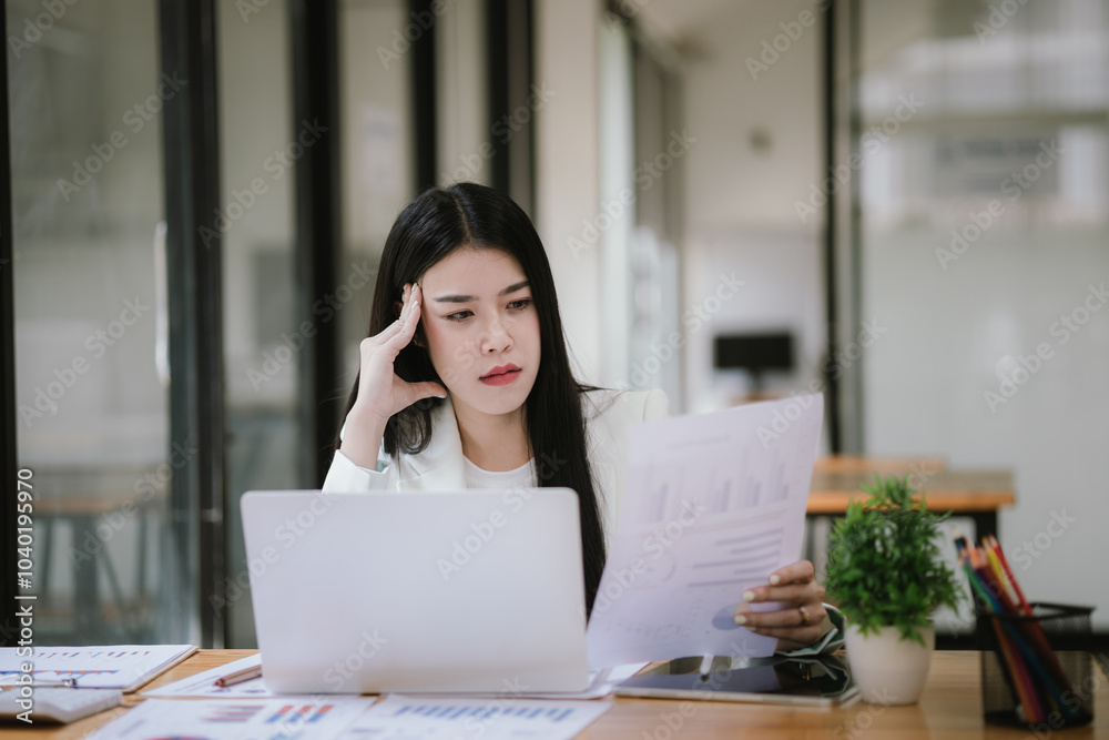 Asian businesswoman stressed about her projects, planning and thinking of new strategies at the office. Asian businesswoman stressed about her projects, planning and thinking of new strategies at the office.