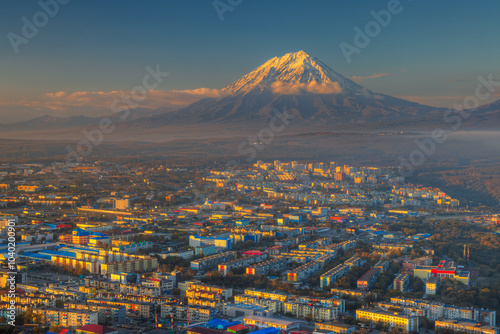 Petropavlovsk-Kamchatsky, Kamchatka Krai, Russia. Beautiful evening cityscape. View from above on the city illuminated by the setting sun. Koryakskaya Sopka volcano in the distance. Russian Far East.