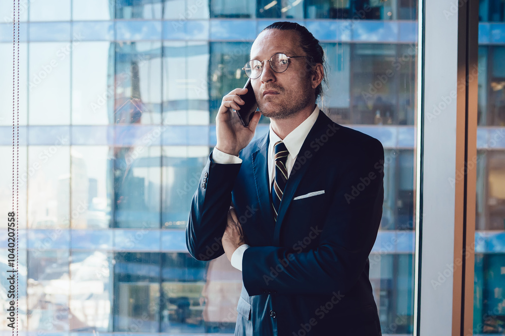 Half length portrait of successful business man having cellphone conversation while standing in office interior, male professional banker in suit talking on mobile phone connected to 4g internet Half length portrait of successful business man having cellphone conversation while standing in office interior, male professional banker in suit talking on mobile phone connected to 4g internet