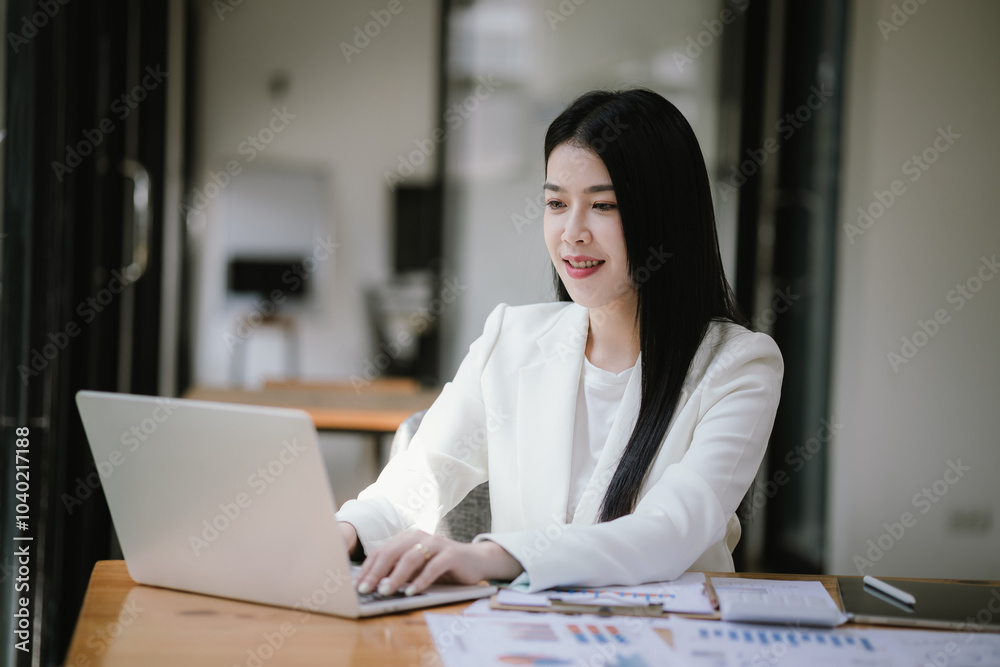 Happy Asian Women's Business Women work at the desk using laptops and calculators to analyze financial data. About the growth of financial and accounting organizations Happy Asian Women's Business Women work at the desk using laptops and calculators to analyze financial data. About the growth of financial and accounting organizations