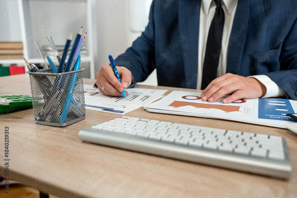 Fototapeta premium businessman hand working with computer and accounting annual report with business document