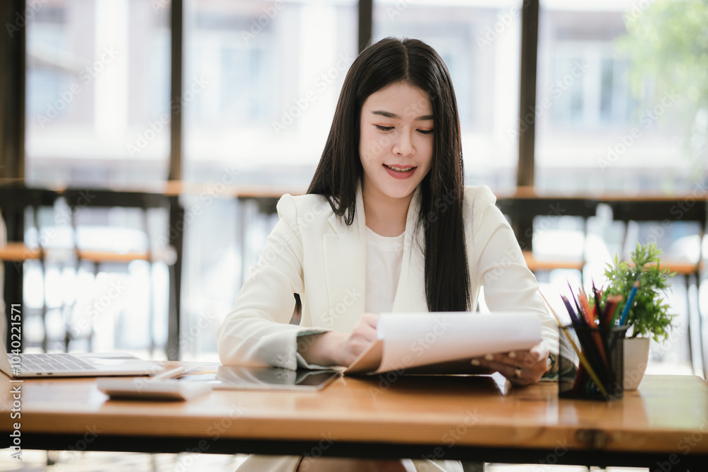 Asian accountant using laptop computer to analyze sales growth in global workplace market. Accounting concept. Asian accountant using laptop computer to analyze sales growth in global workplace market. Accounting concept.
