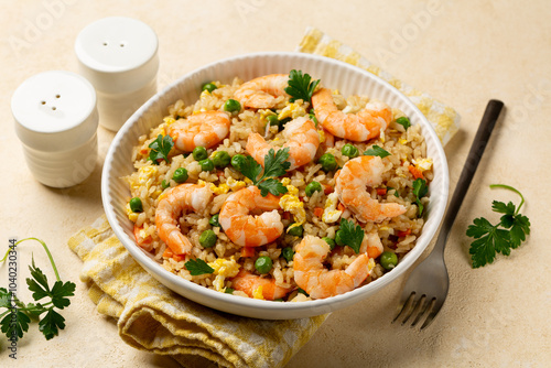 Close up of white bowl with homemade prawns or shrimp fried rice with fried eggs, vegetables, onion, green pea, carrot, parsey. photo