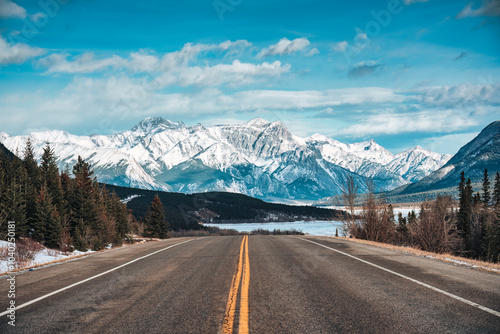 Road trip with on highway road with snow covered rocky mountains in winter at Kootenay plains area, Canada