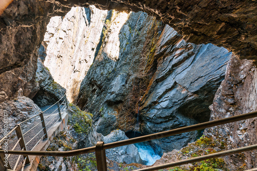 Fotografi Natural limestone cave with stream flowing in Rosenlaui glacier gorge
