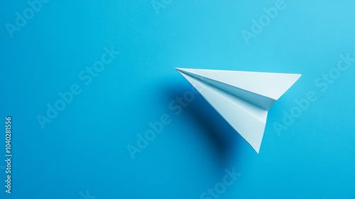 A white paper airplane is flying over a blue background