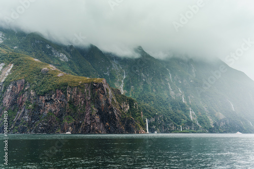 Scenic cruise with natural cascade on mountain in fjord at Milford Sound, New Zealand photo