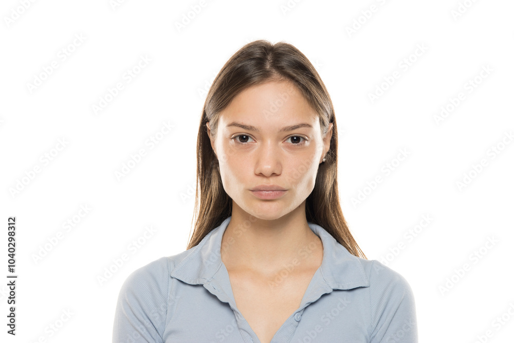 Portrait of a beautiful young serious woman without makeup on a white studio background Portrait of a beautiful young serious woman without makeup on a white studio background