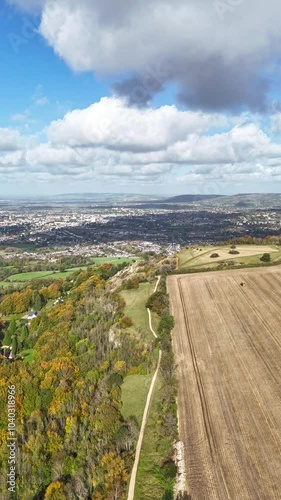 timelapse of clouds flying over a field, forest and town