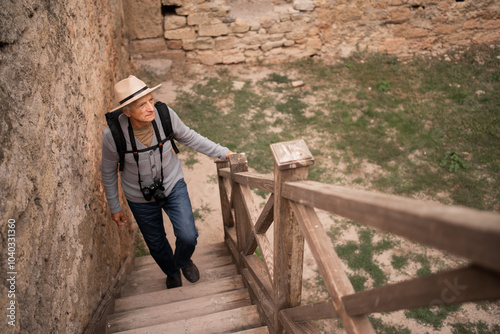 Elderly tourist exploring ancient fortress during journey