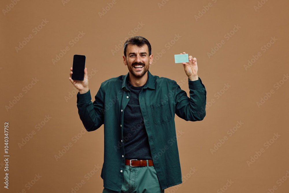 Studio shot of happy man with mobile phone and credit card and looking at camera. Studio shot of happy man with mobile phone and credit card and looking at camera.