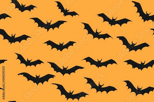 Orange background black bat silhouettes flying in the sky