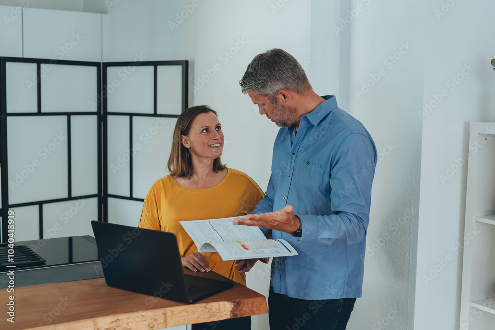 Man and woman smiling professional business people talking using laptop computer working in office.