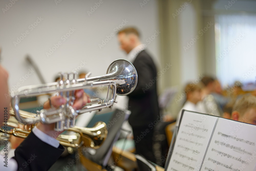 Obraz premium A musician in an orchestra plays a musical composition on a trumpet in an orchestra.