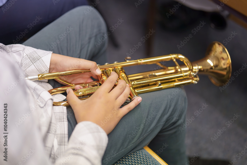 Obraz premium A musician in an orchestra plays a musical composition on a trumpet in an orchestra.