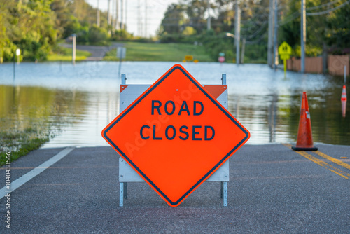 Flooded road. Road or highway closed sign. High water. Florida hurricane and tropical storm season. Heavy rain with wind. Climate Disaster. Flood neighborhood. Global warming. Evacuation zone photo