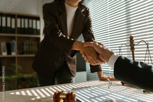 Two lawyers shaking hands in agreement in their office after reaching an agreement in a lawsuit