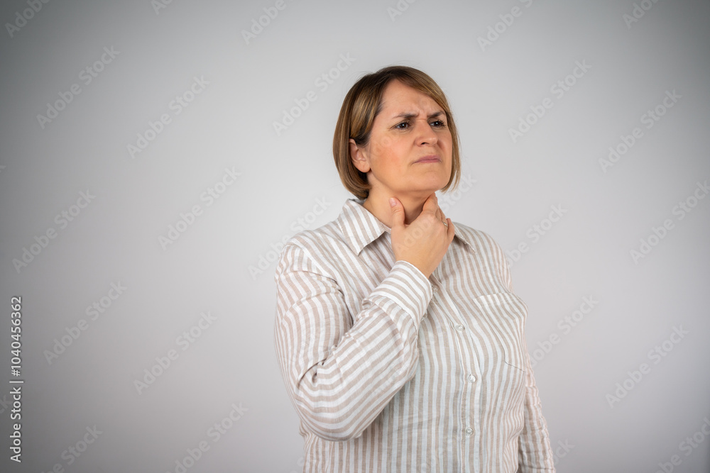 Unhappy caucasian woman in shirt suffering from throat pain at home. Middle aged woman with sore throat isolated on white background. Sick woman having sore throat, tonsillitis, feeling sick, suffer
Unhappy caucasian woman in shirt suffering from throat pain at home. Middle aged woman with sore throat isolated on white background. Sick woman having sore throat, tonsillitis, feeling sick, suffer