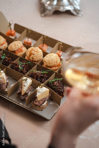 Assorted Appetizers in Box with Champagne in Background