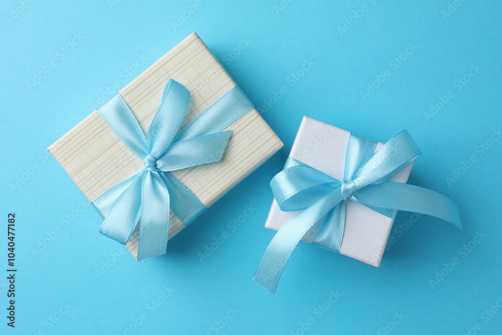 Gift boxes with bows on light blue background, flat lay Gift boxes with bows on light blue background, flat lay