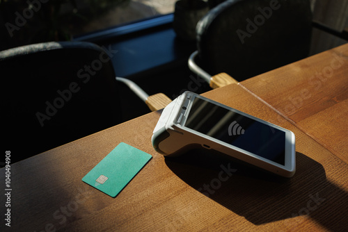 Close-up of payment terminal and credit card on table background. Credit card payment. photo