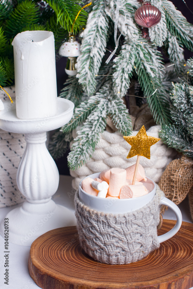 A New Year's festive hot drink with marshmallows next to the Christmas tree on the table. the concept of the New Year A New Year's festive hot drink with marshmallows next to the Christmas tree on the table. the concept of the New Year