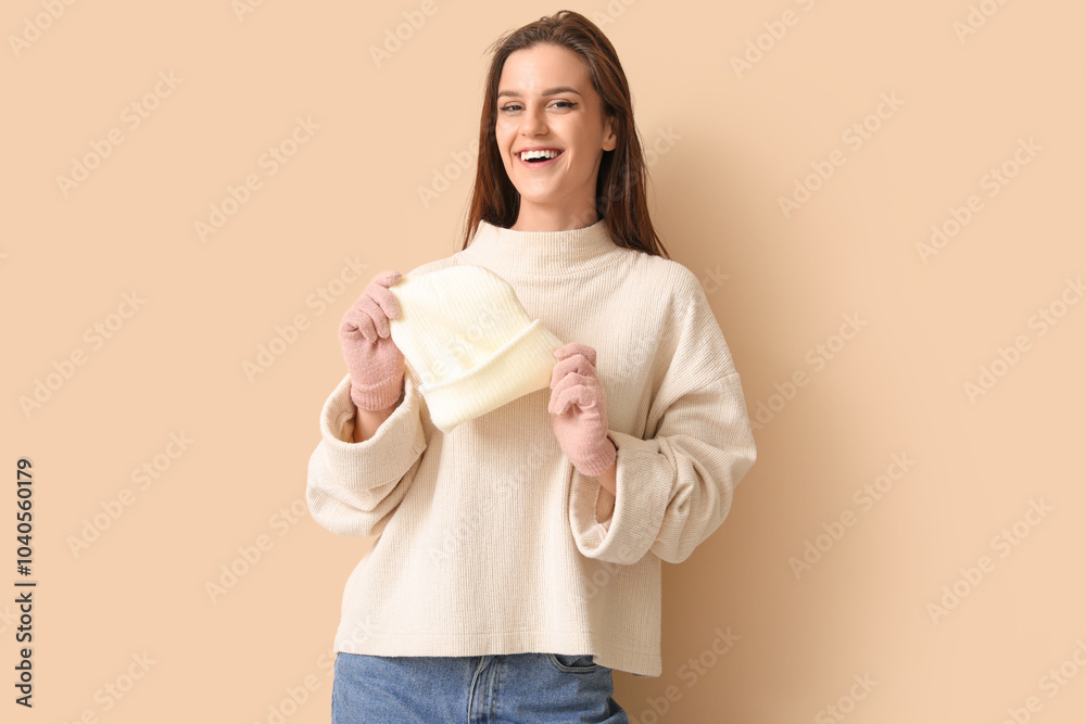 Young woman in winter clothes on beige background Young woman in winter clothes on beige background
