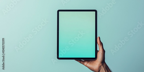 Hand holding digital tablet with minimalistic design on a gradient background photo