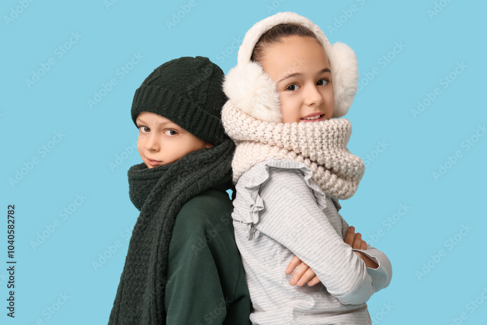 Cute little happy children in warm winter clothes on blue background Cute little happy children in warm winter clothes on blue background
