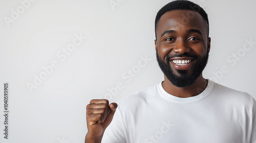  man with a wide smile and clenched fist, wearing a white t-shirt photo