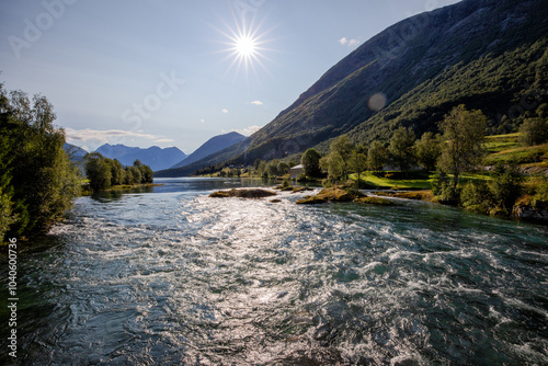 flusslandschaft mit wald und sonnenstrahlen in norwegen photo