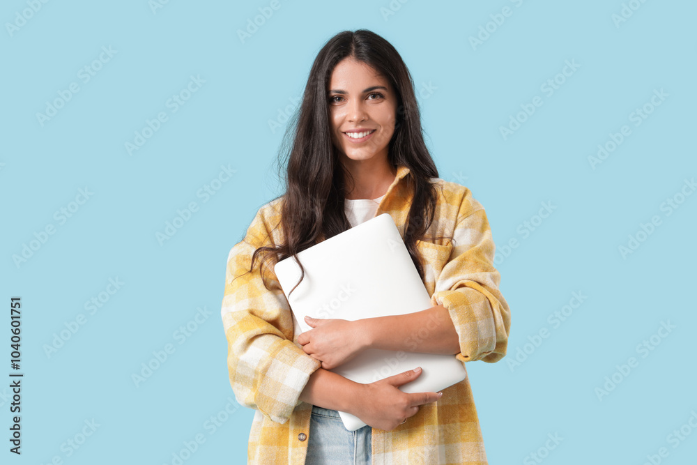 Portrait of pretty young woman with laptop on blue background Portrait of pretty young woman with laptop on blue background