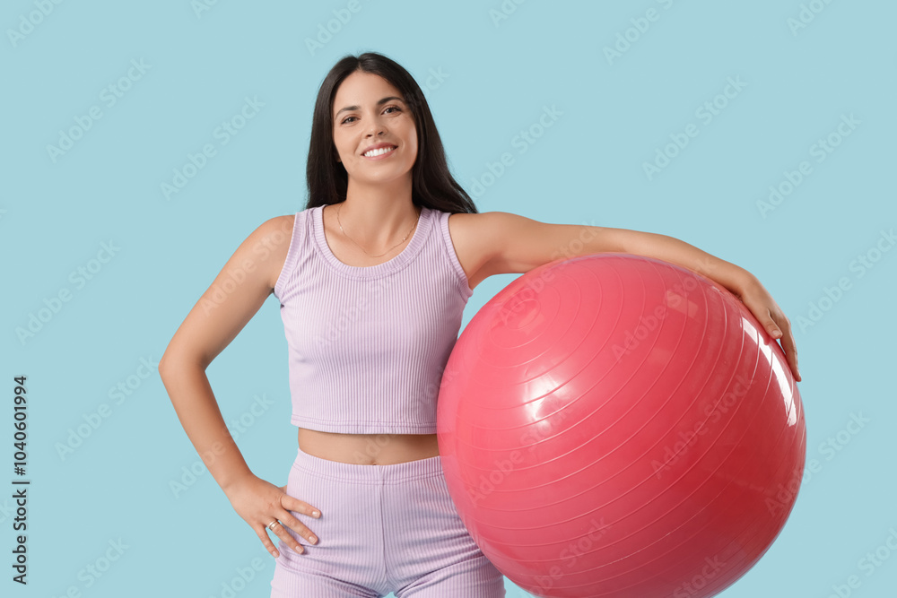 Portrait of sporty young woman with fitball on blue background Portrait of sporty young woman with fitball on blue background