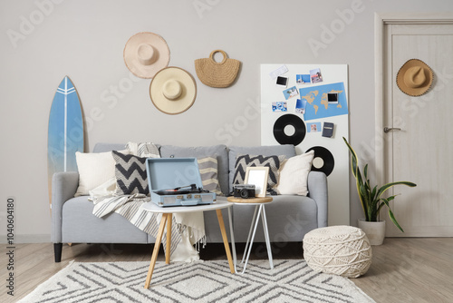 Interior of stylish living room with grey sofa, record player and mood board photo