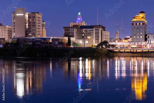 Monroe, Louisiana, USA - April 4, 2024: Evening lights shine on the historic buildings, skyline and river of downtown Monroe.