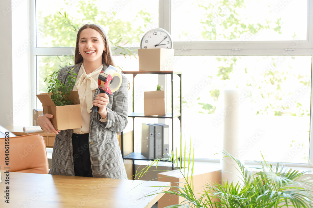 Young businesswoman with cardboard box and adhesive tape in office on moving day Young businesswoman with cardboard box and adhesive tape in office on moving day