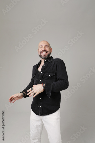 Portrait of mature bald man with beard, posing confidently indoors. Vetical.