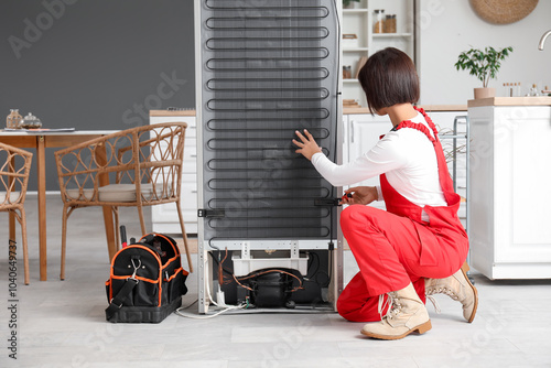 Female worker repairing fri...