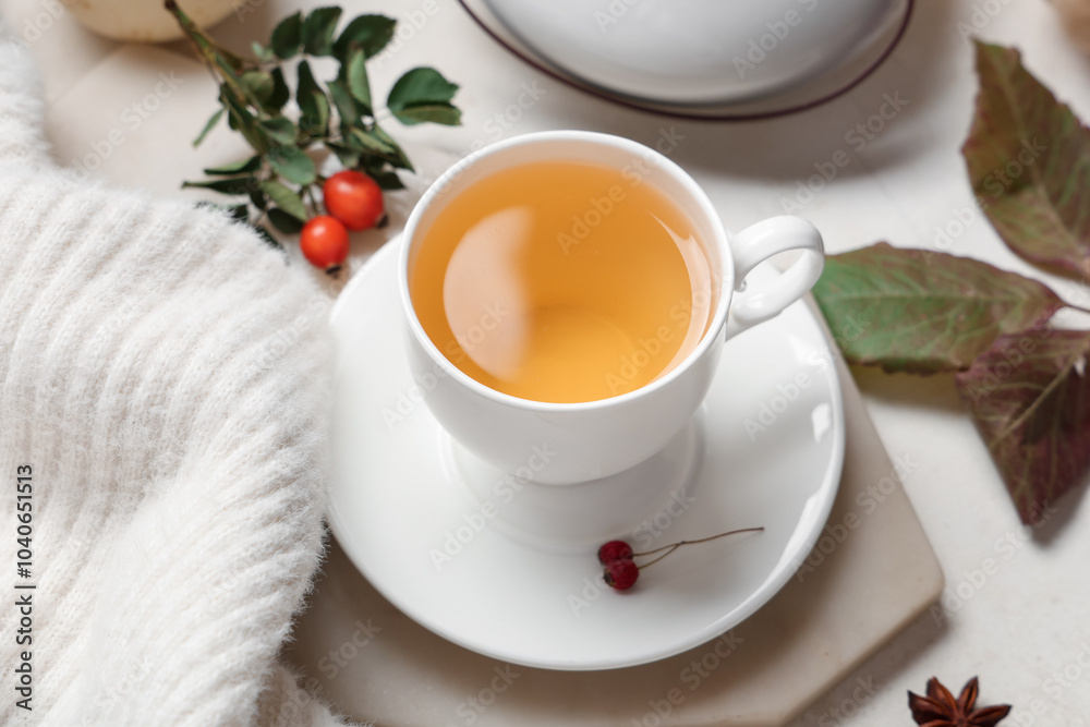 Composition with cup of green tea, sweater and autumn leaves on white background, closeup