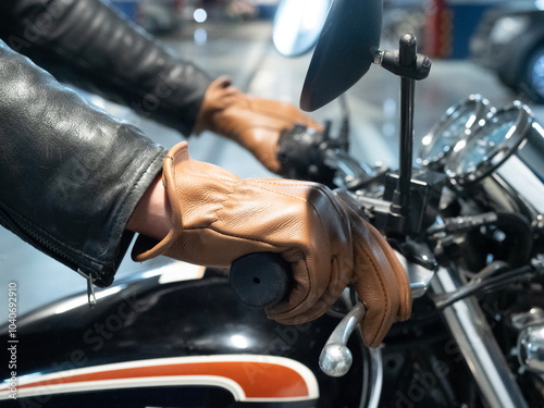 close-up of a motorcyclist's hand dressed in a brown leather glove photo