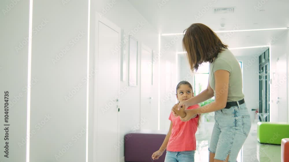 A Mother Brings Her Daughter to the Doctor, but the Child Resists and is Afraid, Showing Fear and Reluctance in a Medical Visit A Mother Brings Her Daughter to the Doctor, but the Child Resists and is Afraid, Showing Fear and Reluctance in a Medical Visit