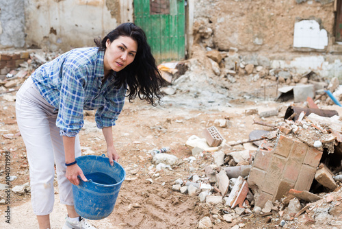 Adult Asian woman is staning among ruins photo