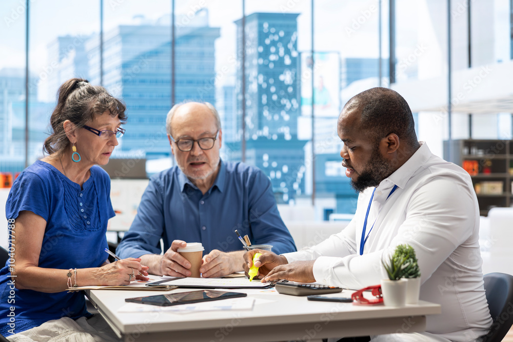 Elderly couple discussing about retirement plans with a financial planner, covering savings strategy and pension options. Middle aged people looking to invest to secure their budget.